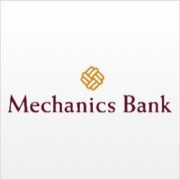 In the image, mechanics are working on a car at a bank. Full Text: Mechanics Bank