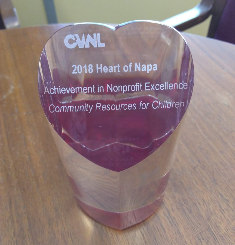 The image is showing recognition of Community Resources for Children for their achievement in nonprofit excellence at the CUAL 2018 Heart of Napa event. Full Text: CUAL 2018 Heart of Napa Achievement in Nonprofit Excellence Community Resources for Children