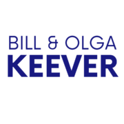 Bill and Olga Keever are standing together in a garden, smiling and embracing. Full Text: BILL & OLGA KEEVER