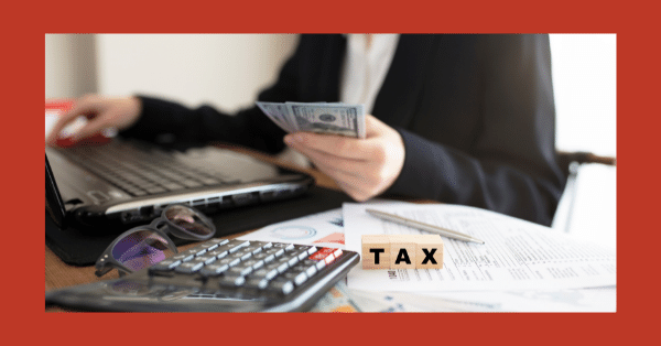 A person is typing on a computer keyboard surrounded by office equipment and supplies in an indoor office.